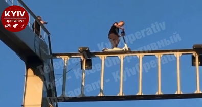 В Киеве парень забрался на мост, чтобы прокатится на самокате (ФОТО)
